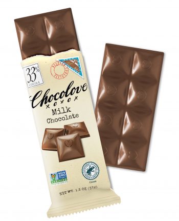 A Chocolove Milk Chocolate bar is partially unwrapped, revealing smooth milk chocolate squares with embossed heart designs. The wrapper is a soft, cream-colored paper with an elegant vintage-inspired design. It features an illustration of three glossy chocolate squares, a stamp-like cocoa illustration, and a 33% cocoa label in the top left corner. The bar has a rich, velvety texture, showcasing its premium Belgian chocolate quality.