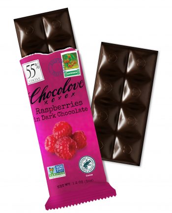 A Chocolove Raspberries in Dark Chocolate bar is partially unwrapped, revealing dark chocolate squares with embossed heart designs. The wrapper is a vibrant raspberry-pink color with an elegant, vintage-inspired design. It features an image of fresh, ripe raspberries, emphasizing the fruity contrast against the rich dark chocolate. A 55% cocoa label is displayed in the top left corner, with a stamp-style illustration of raspberries and a blue Belgian Chocolate seal near the top. The glossy surface of the chocolate highlights its premium Belgian quality.