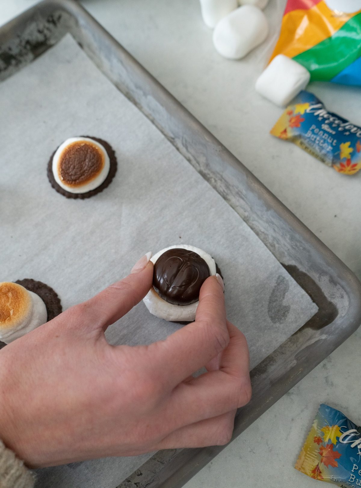 Closeup image of Fall-inspired s’mores cookies made with Chocolove’s limited-release pumpkin-shaped peanut butter in dark chocolate bites, marshmallows, and chocolate cookies, ready to bake on a tray